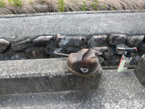 ガスバーナーで加熱して、マフラーの再生を行っています。